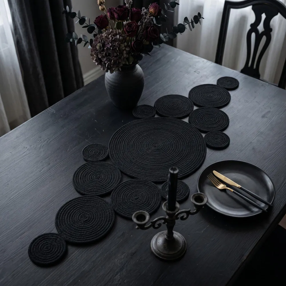 Modern gothic dining room decor with black cotton rope centerpiece and black candle holders